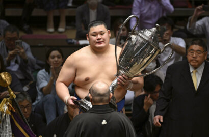 Onosato reçoit la Coupe de l'Empereur des mains du chef de l'Association japonaise de sumo, Hakkaku.