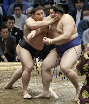 L'ôzeki Onosato (à droite) s'incline face à Wakamotoharu lors de la quatrième journée du Haru Bashô à l'Edion Arena d'Osaka, le 12 mars 2025. (Kyodo)