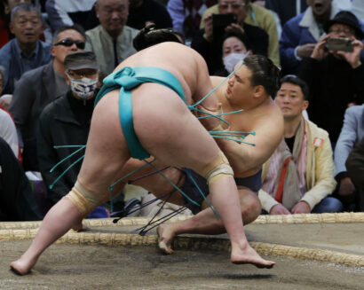 Ichiyamamoto (de dos) bat le yokozuna Hoshoryu lors de la neuvième journée du Haru Bashô à l'Edion Arena d'Osaka, le 17 mars 2025. (Kyodo)